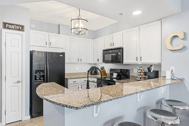a kitchen with stainless steel appliances granite countertop a sink refrigerator and microwave