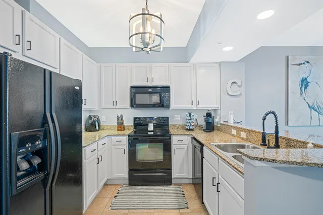 a kitchen with stainless steel appliances granite countertop a refrigerator a sink a stove top oven and cabinets
