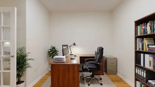 a view of a workspace with furniture and a book shelf