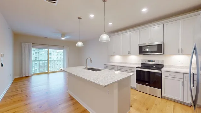 a kitchen with granite countertop a stove top oven and sink