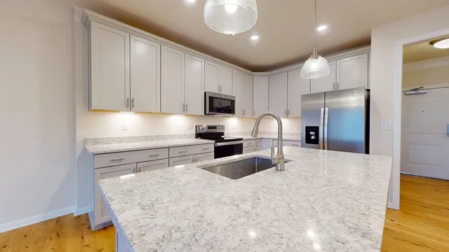 a kitchen with granite countertop a refrigerator stove and microwave