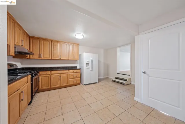 a kitchen with stainless steel appliances granite countertop a stove a sink and a refrigerator