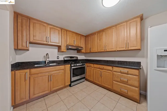a kitchen with granite countertop cabinets stainless steel appliances and a sink