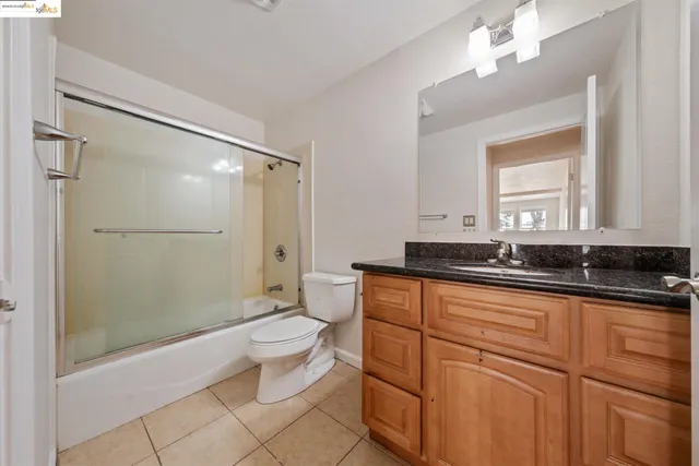 a bathroom with a sink a toilet a mirror and shower