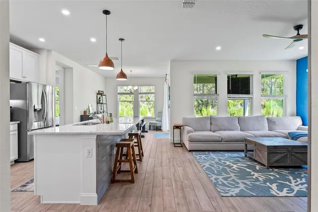 a kitchen with stainless steel appliances kitchen island granite countertop a sink a stove and a refrigerator