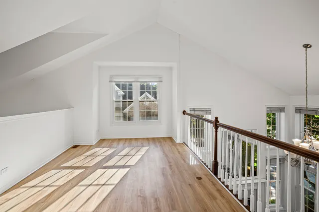 a view of a hallway with wooden floor and staircase