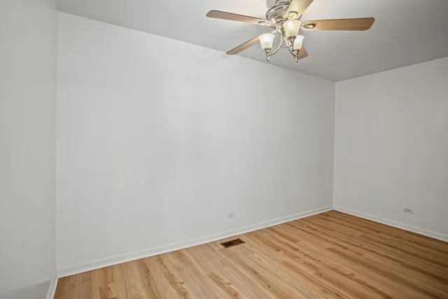 a view of a room with wooden floor and ceiling fan