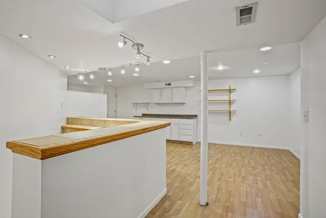 a room with pool table and kitchen view