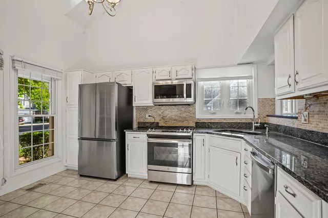 a kitchen with stainless steel appliances granite countertop a refrigerator sink and stove