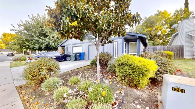 a front view of a house with a yard and fountain