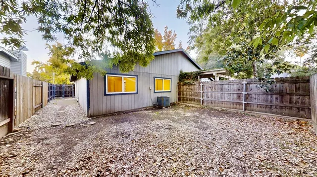 a view of a house with a small yard and wooden fence