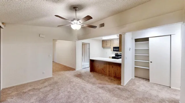 a view of an empty room with a kitchen