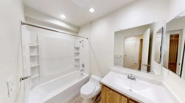 a bathroom with a granite countertop sink toilet and shower