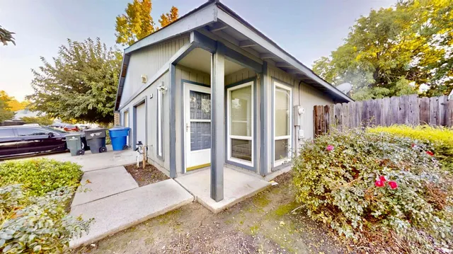 a view of a house with a small yard and potted plants