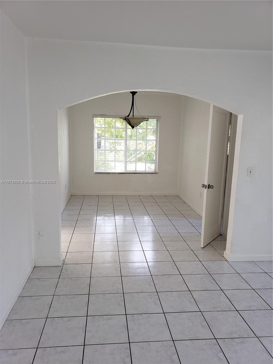 6912 Northeast 5th Avenue, Unit 2 Miami, FL 33138 - Photo 13 of 18 an empty room with windows and entrance
