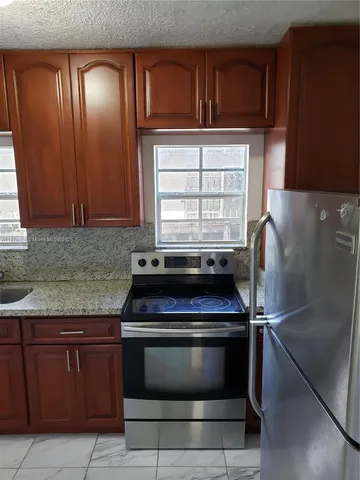 a kitchen with granite countertop a stove and a sink