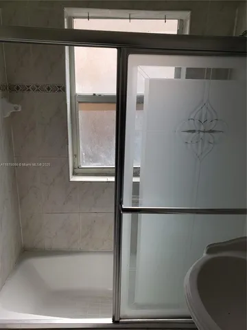 a bathroom with a granite countertop bathtub shower sink and toilet