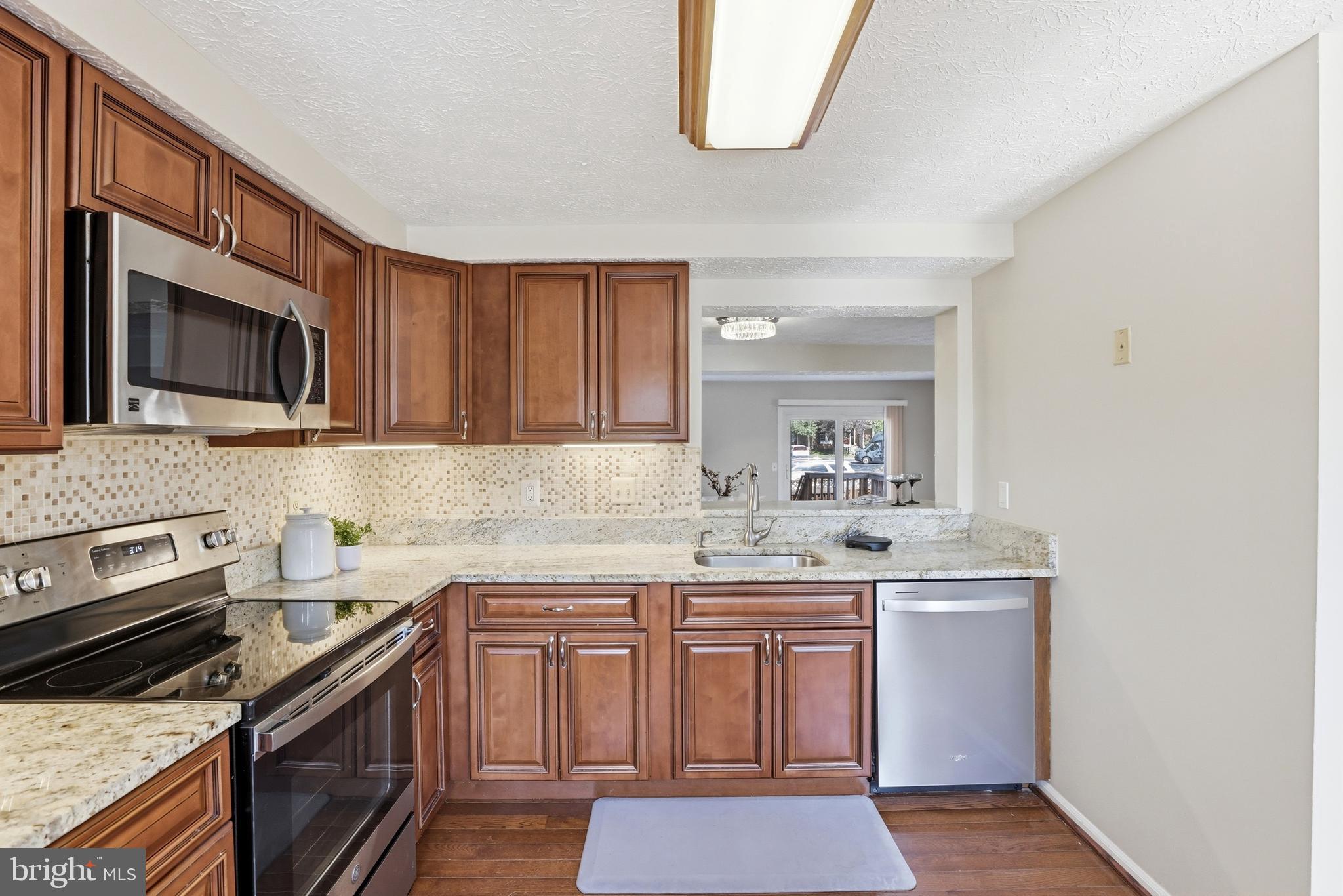 6167 Morning Glory Road Alexandria, VA 22310 - Photo 15 of 39 a kitchen with stainless steel appliances a sink stove and microwave