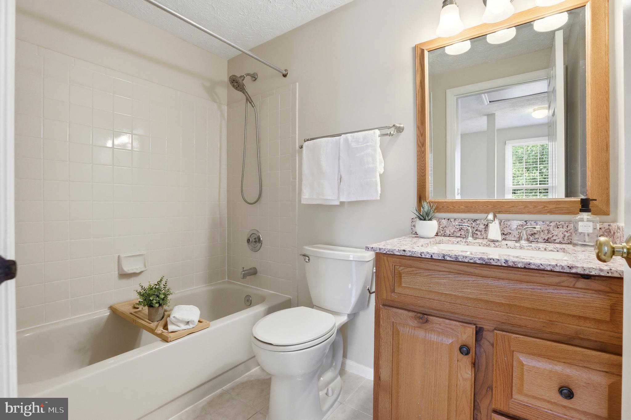 6167 Morning Glory Road Alexandria, VA 22310 - Photo 22 of 39 a bathroom with a granite countertop sink a toilet a mirror and shower