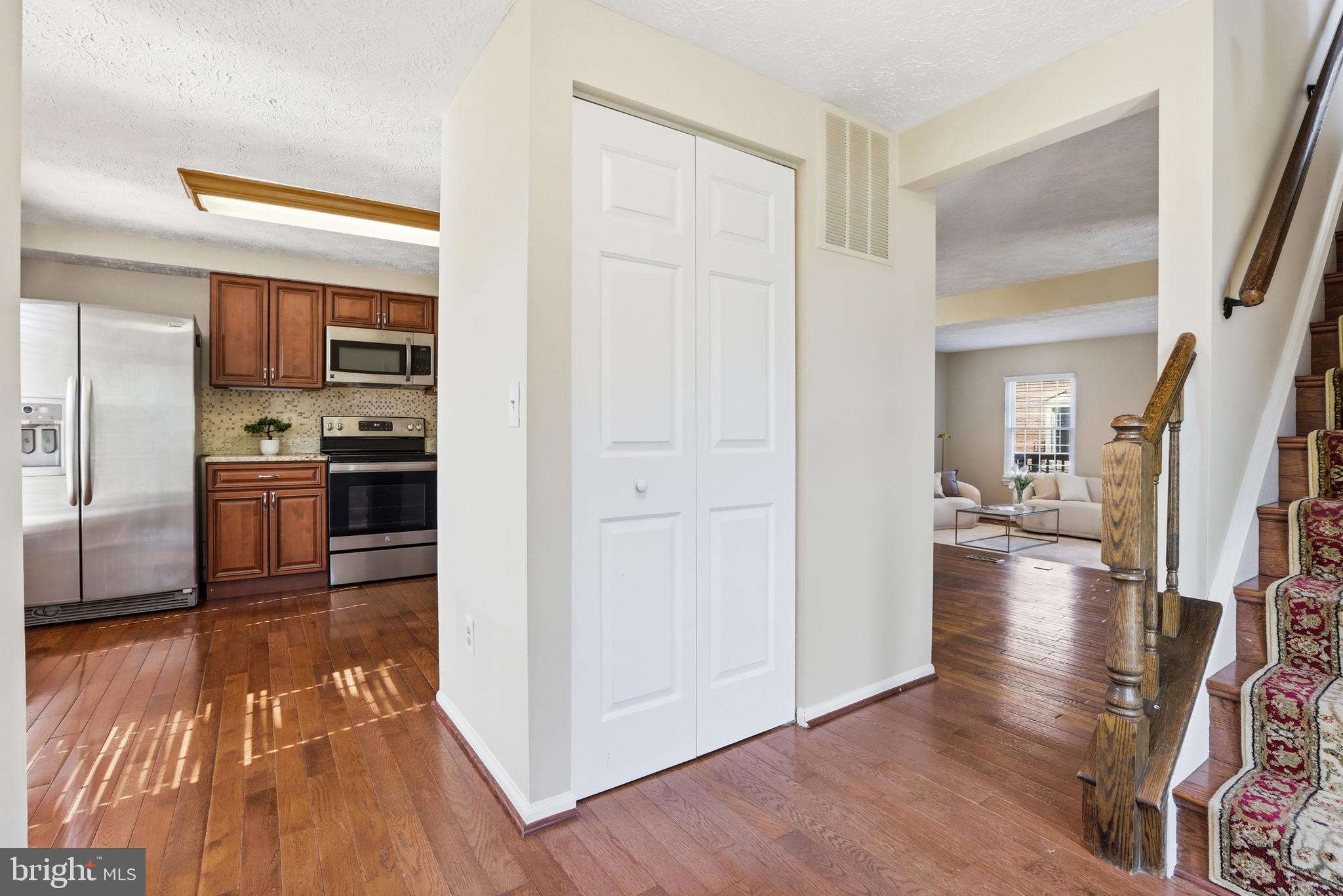 6167 Morning Glory Road Alexandria, VA 22310 - Photo 7 of 39 a view of a kitchen from the hallway with a sink and wooden floor
