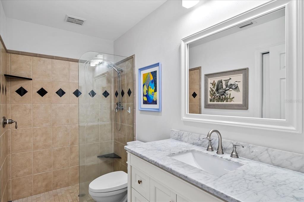 184 Colony Point Drive Punta Gorda, FL 33950 - Photo 37 of 58 a bathroom with a granite countertop sink toilet a shower and a mirror