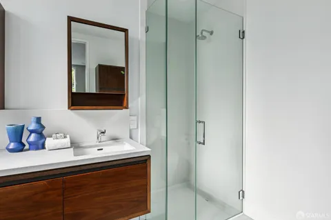 a bathroom with a sink a mirror and shower