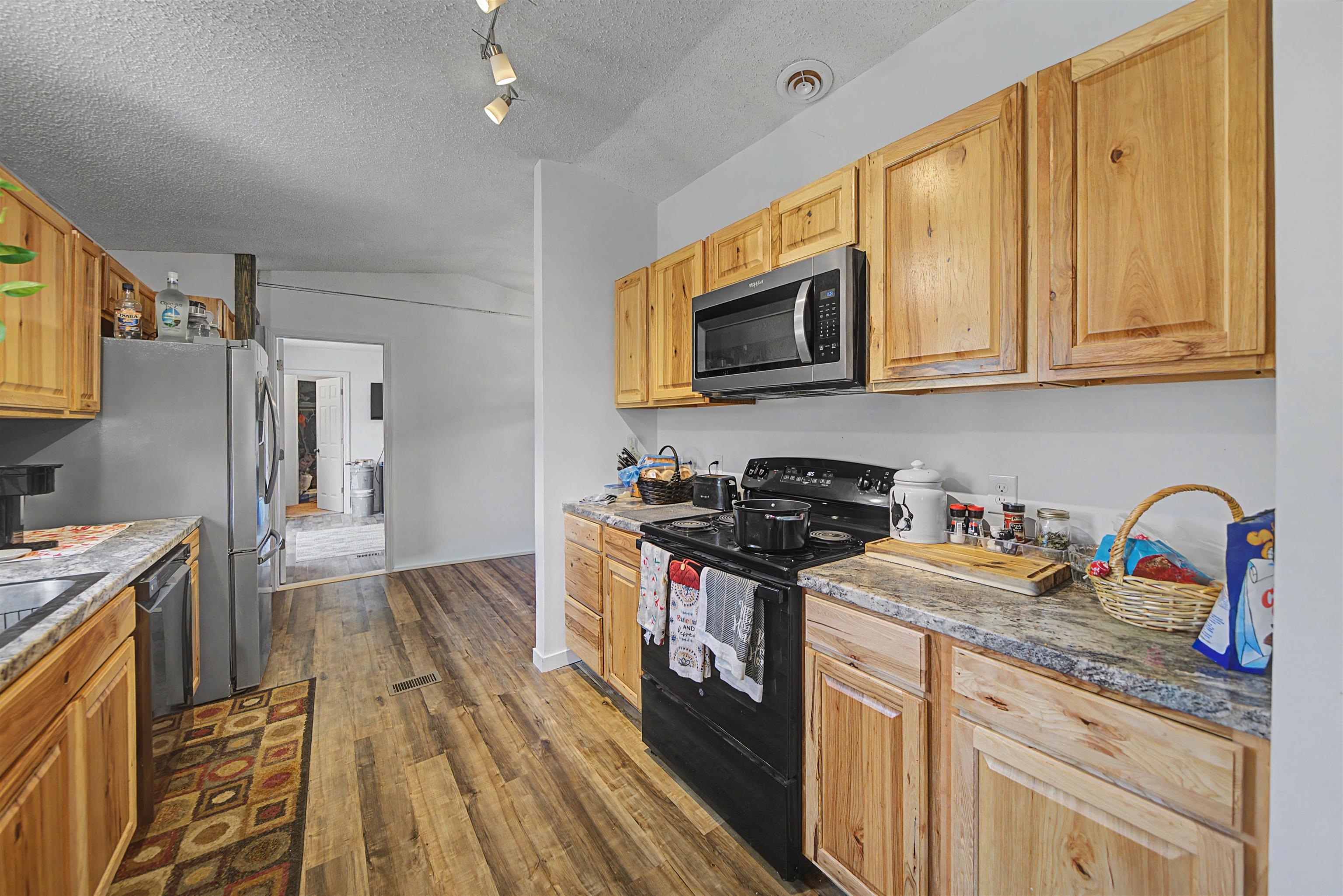 7010 22nd Highway Adamsville, TN 38310 - Photo 8 of 33 Kitchen featuring black appliances and dark wood-style flooring