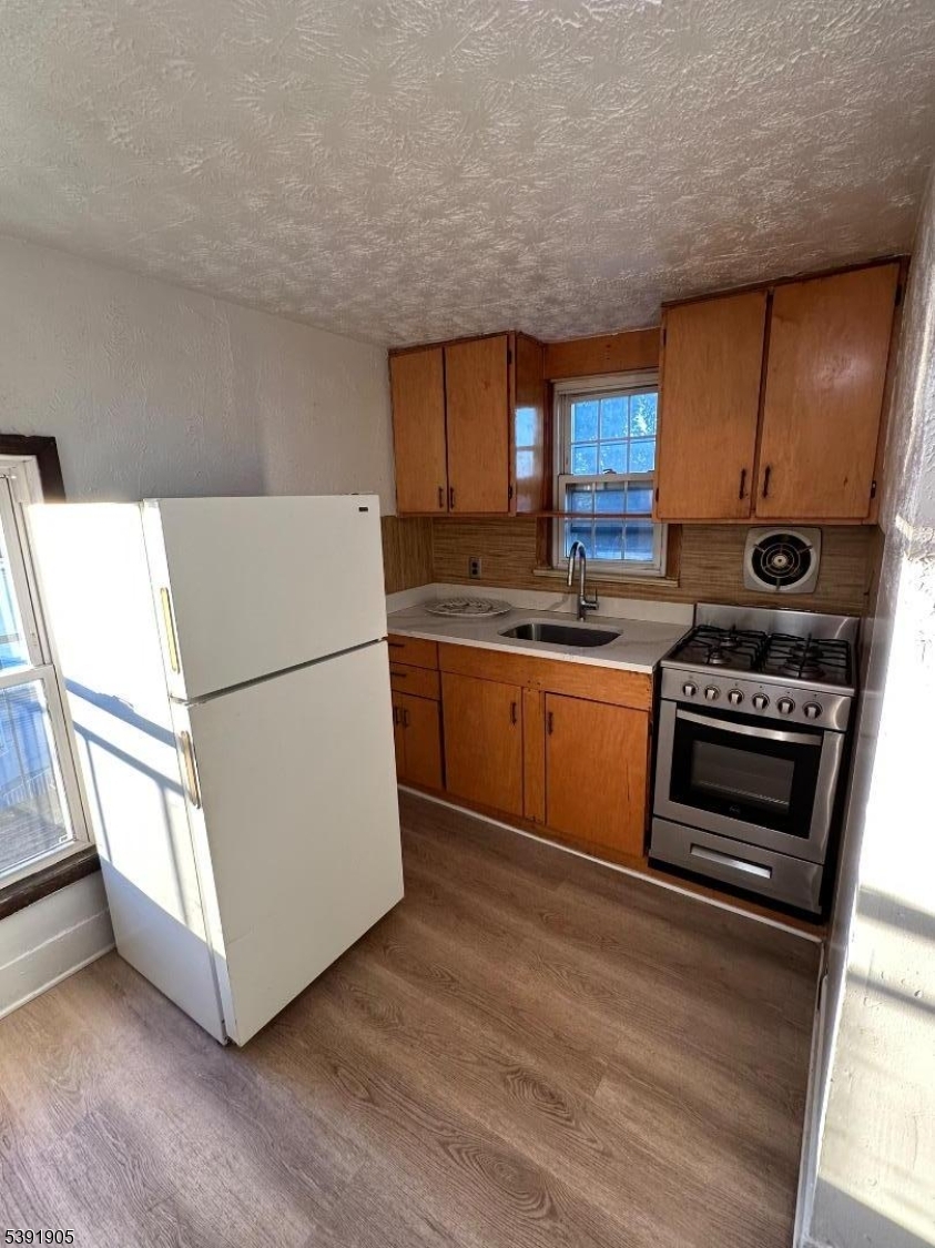 421 Ellison Street Paterson, NJ 07501 - Photo 4 of 12 a kitchen with appliances a sink and a stove