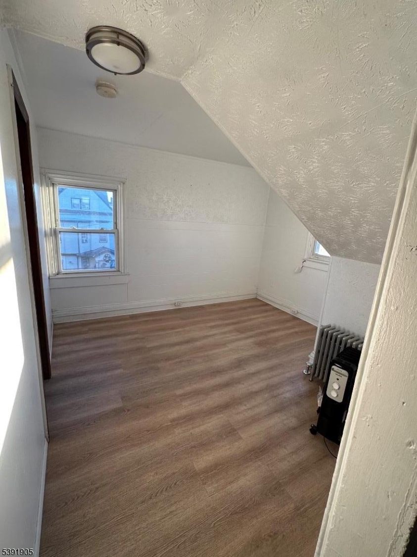 421 Ellison Street Paterson, NJ 07501 - Photo 7 of 12 a view of room with window and hardwood floor