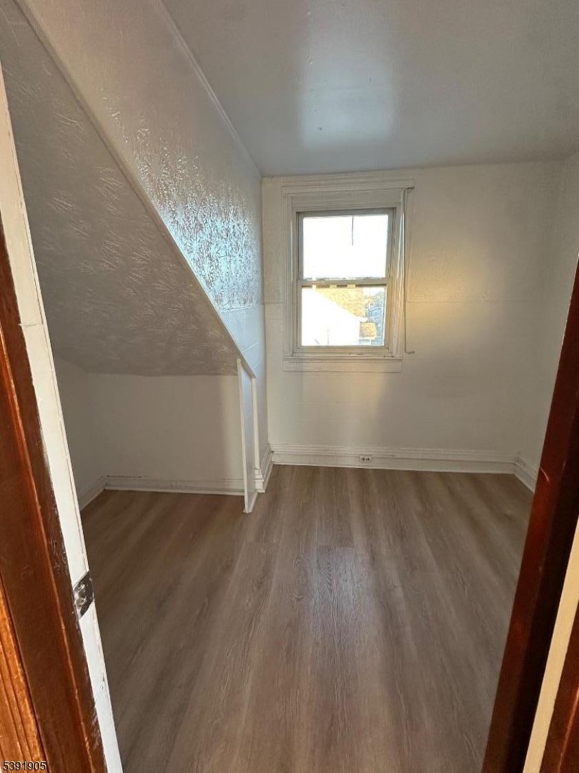 421 Ellison Street Paterson, NJ 07501 - Photo 8 of 12 a view of an empty room and wooden floor