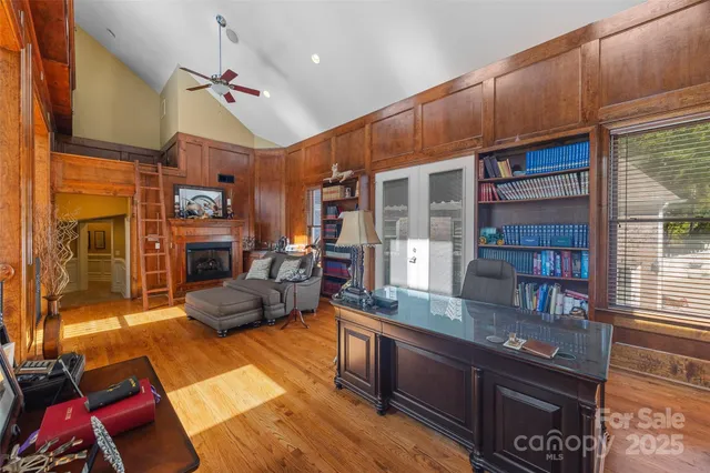 a living room with furniture a clock potted plant and a large window
