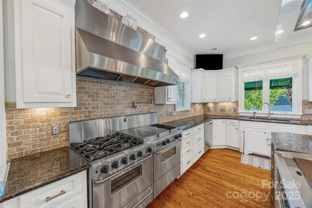 a kitchen with stainless steel appliances granite countertop a stove and a sink