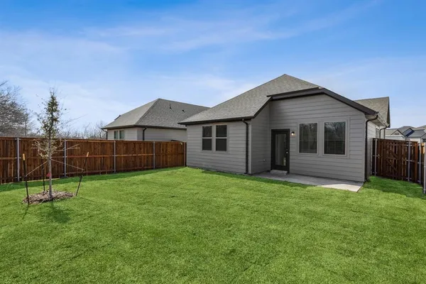a view of a house with a yard and wooden fence