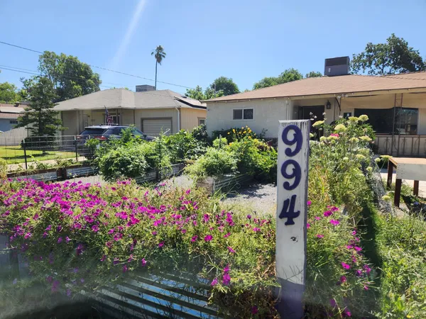 a front view of a house with a yard and fountain