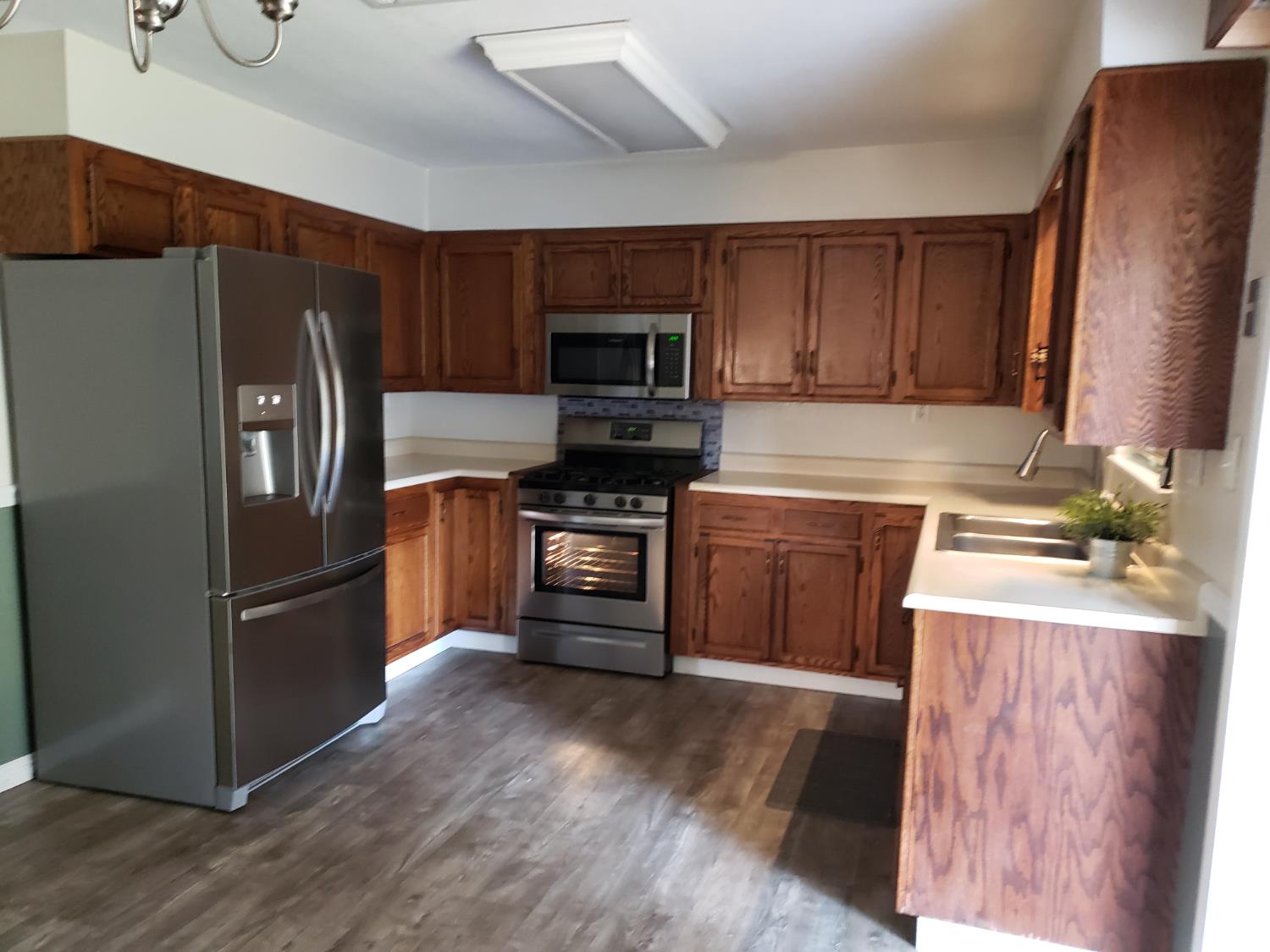 994 Fleda Avenue Olivehurst, CA 95961 - Photo 4 of 20 a kitchen with granite countertop a refrigerator stove and microwave