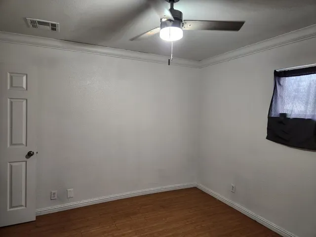 a view of a room with wooden floor and ceiling fan