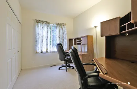 a view of a workspace with furniture and a window