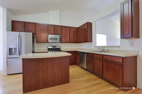 a kitchen with stainless steel appliances granite countertop a refrigerator stove a sink and dishwasher