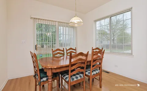 a dining room with furniture a chandelier and wooden floor