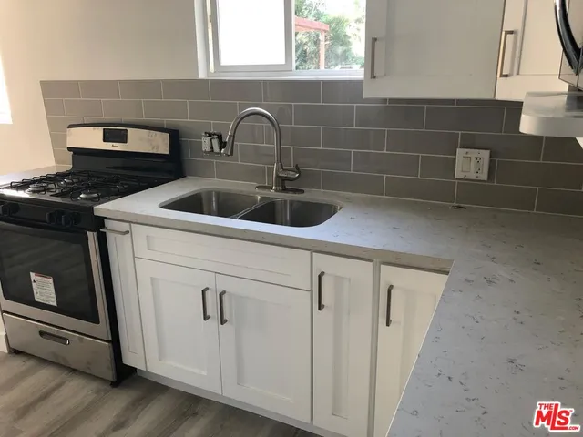 a view of a kitchen sink with wooden floor