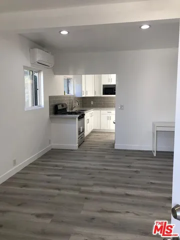 a kitchen with a sink cabinets and wooden floor