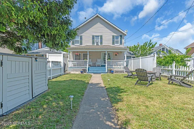 a view of house with a yard and sitting area