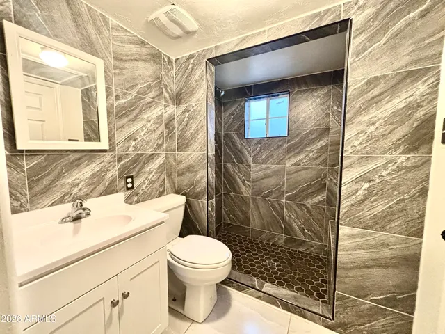 a view of a hallway with wooden floor and a bathroom
