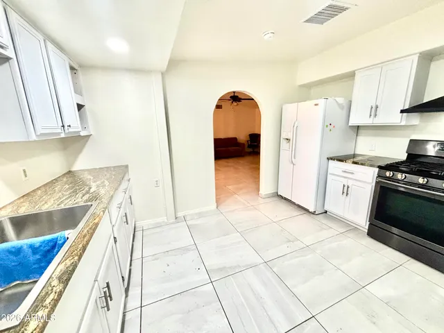 a kitchen with stainless steel appliances granite countertop a refrigerator and a stove