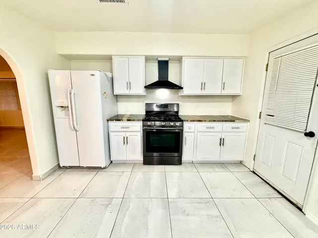 a kitchen with a stove top oven and white cabinets