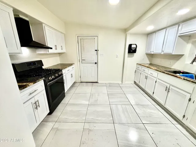 a kitchen with stainless steel appliances granite countertop a stove a sink and a microwave