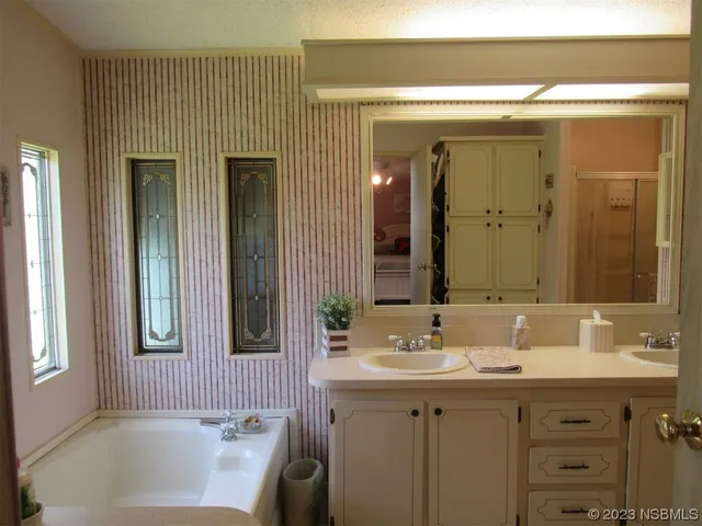a bathroom with a sink mirror and a bathtub