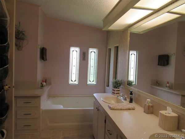a bathroom with a tub a sink and mirror