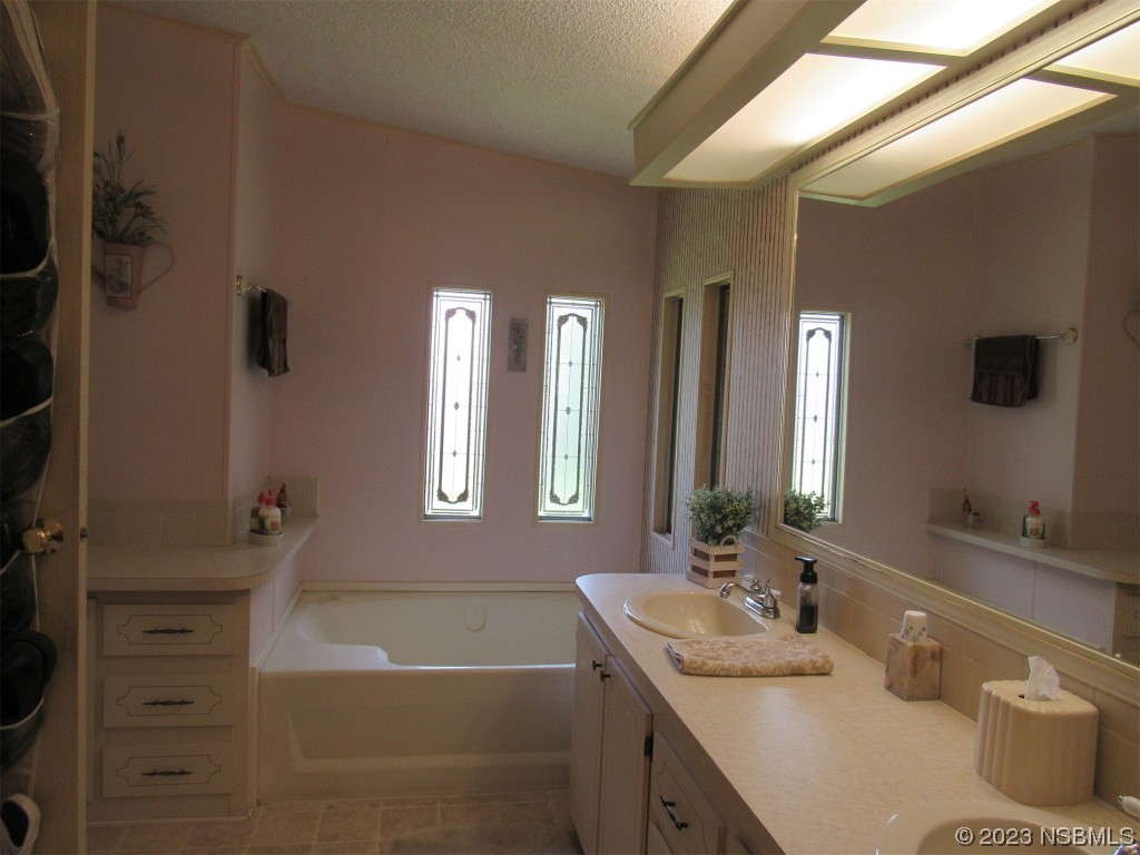 4347 Cedar Way Edgewater, FL 32141 - Photo 22 of 32 a bathroom with a tub a sink and mirror