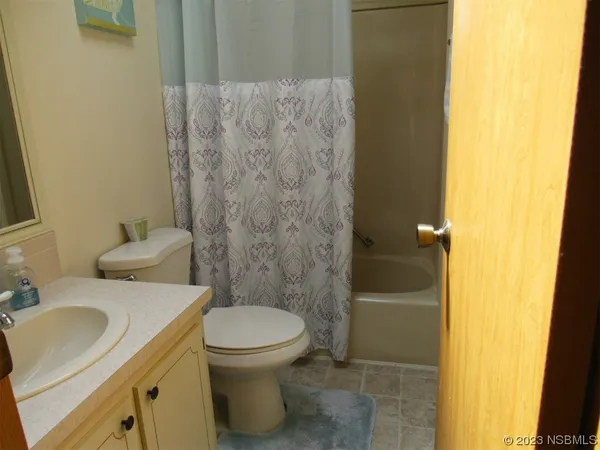 a bathroom with a granite countertop toilet and a sink